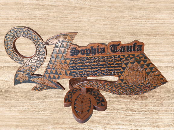 21st Key Shape Tongan Design Carving on a stand with name cut out and coloured.